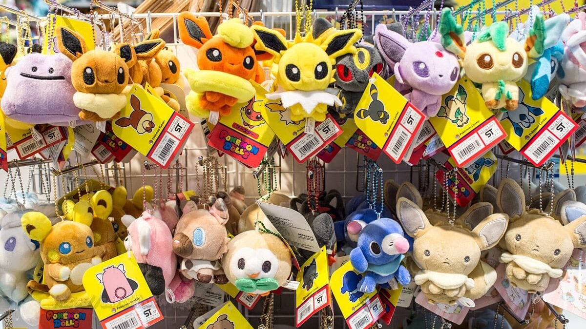 Pokémon-themed merchandise including plush toys, keychains, and stationery in a vending machine.