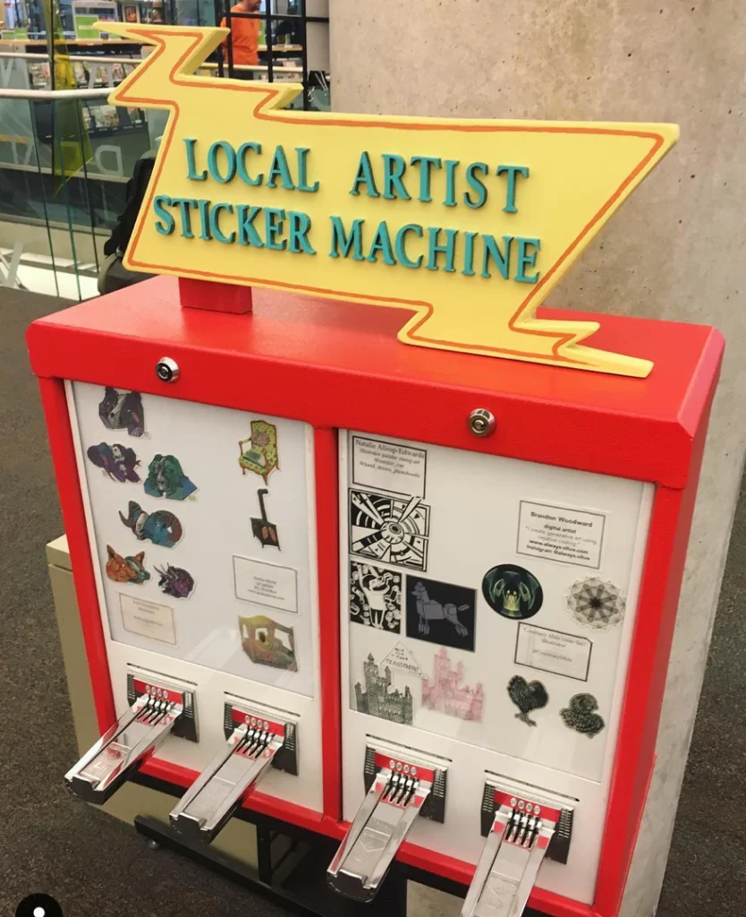 artist selling stickers via vending machine at market